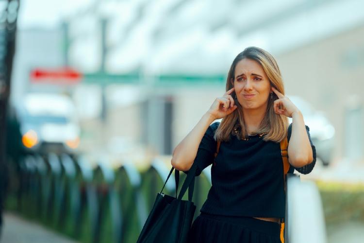 mujer tapandose los oídos mujer tapandose los oídos